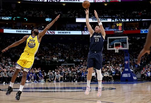 Golden State Warriors' Andrew Wiggins contesting a jumper by Dallas Mavericks' Luka Doncic.