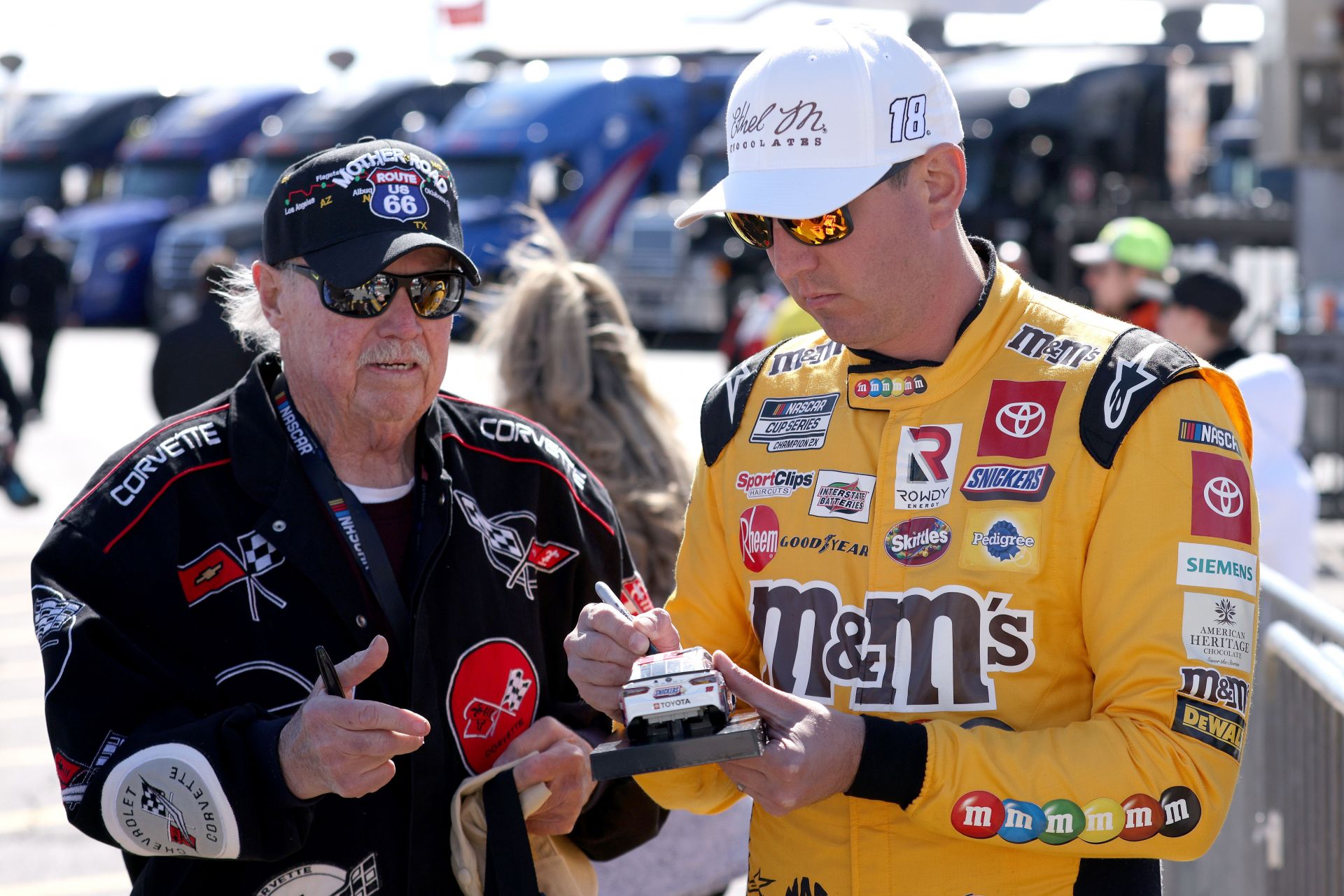 Kyle Busch signs an autograph for a fan during practice for NASCAR Cup Series Pennzoil 400 at Las Vegas Motor Speedway