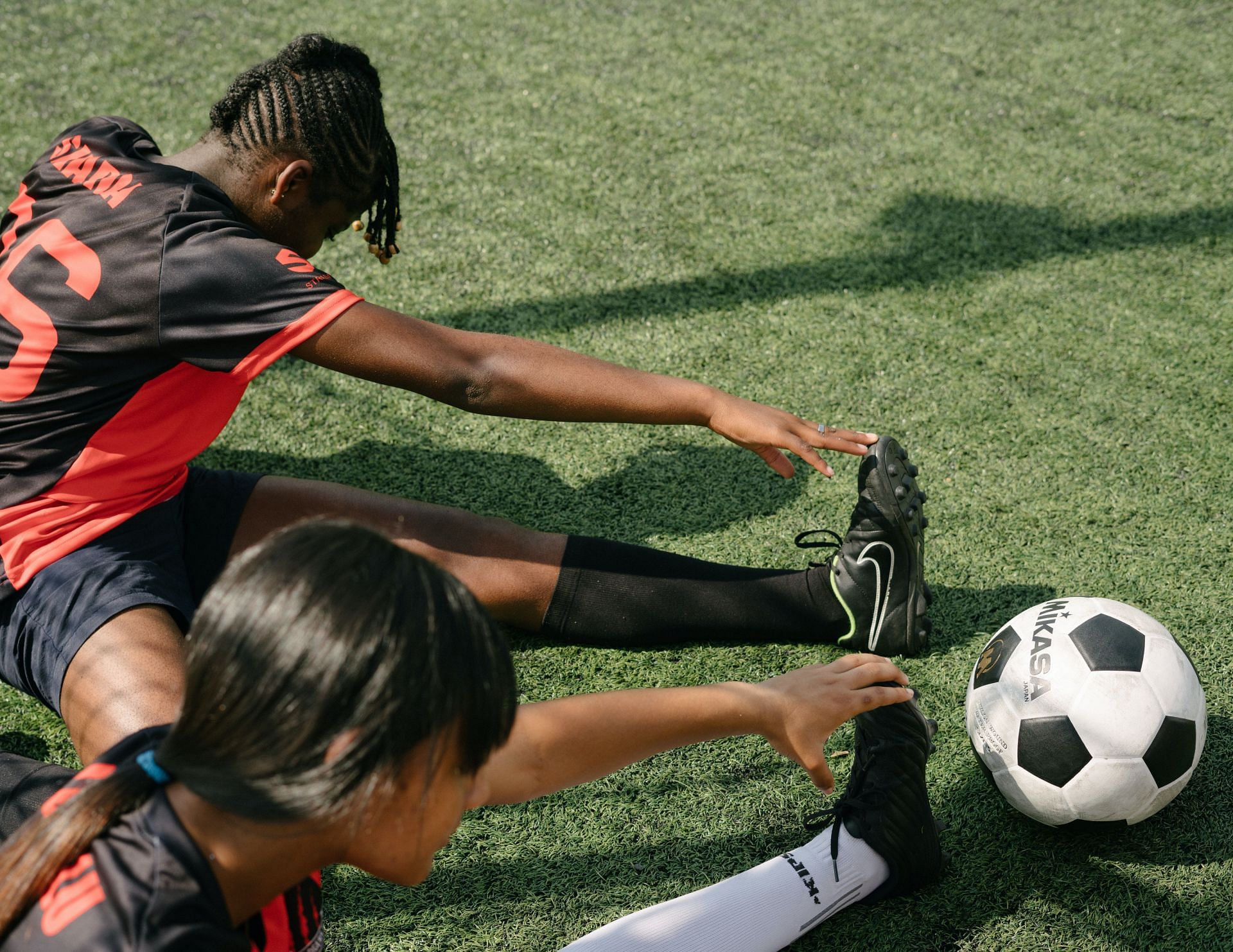 Athletes stretching their hamstring to improve mobility (Image via Pexels/ Rfstudio)