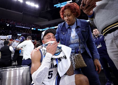 Justin Moore receives consolation from his parents while his teammates celebrate the Final Four trip.