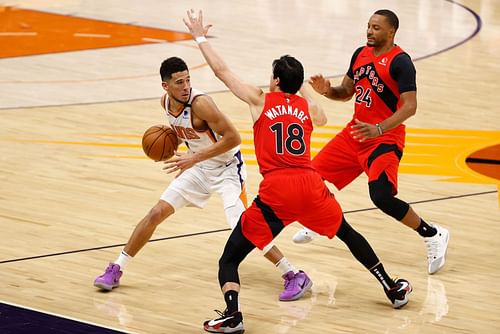 Yuta Watanabe (#18) of the Toronto Raptors v guards Devin Booker (L) of the Phoenix Suns