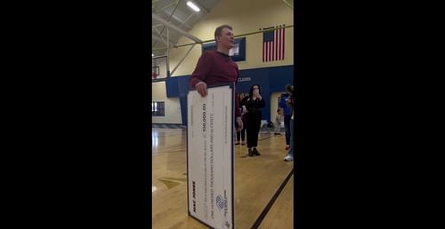 Mac Jones holding a massive check - Credit: Alexandra Francisco