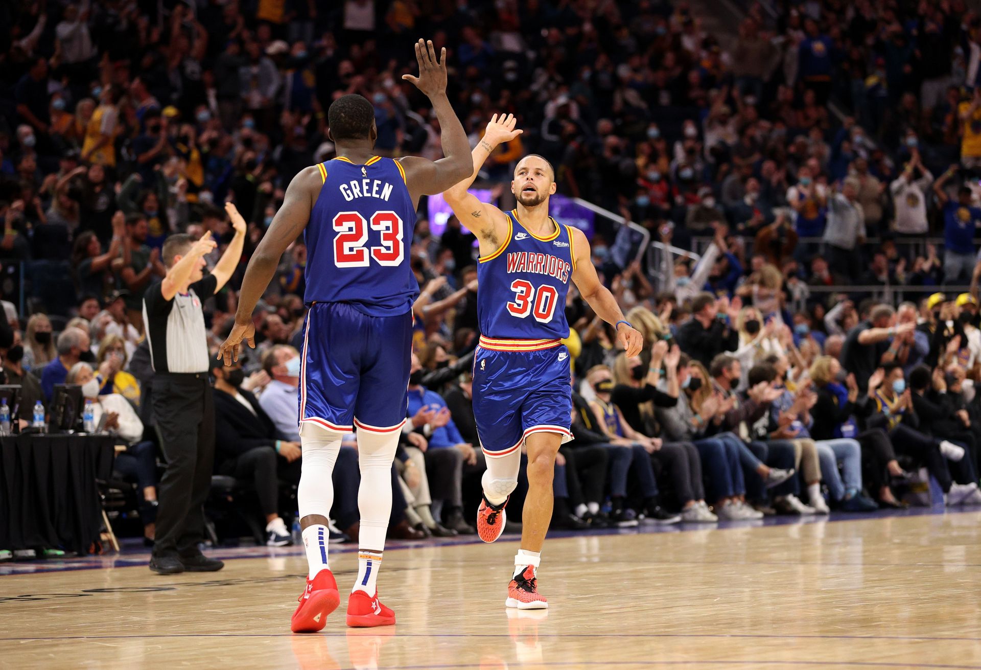 Stephen Curry #30 of the Golden State Warriors reacts with Draymond Green #23