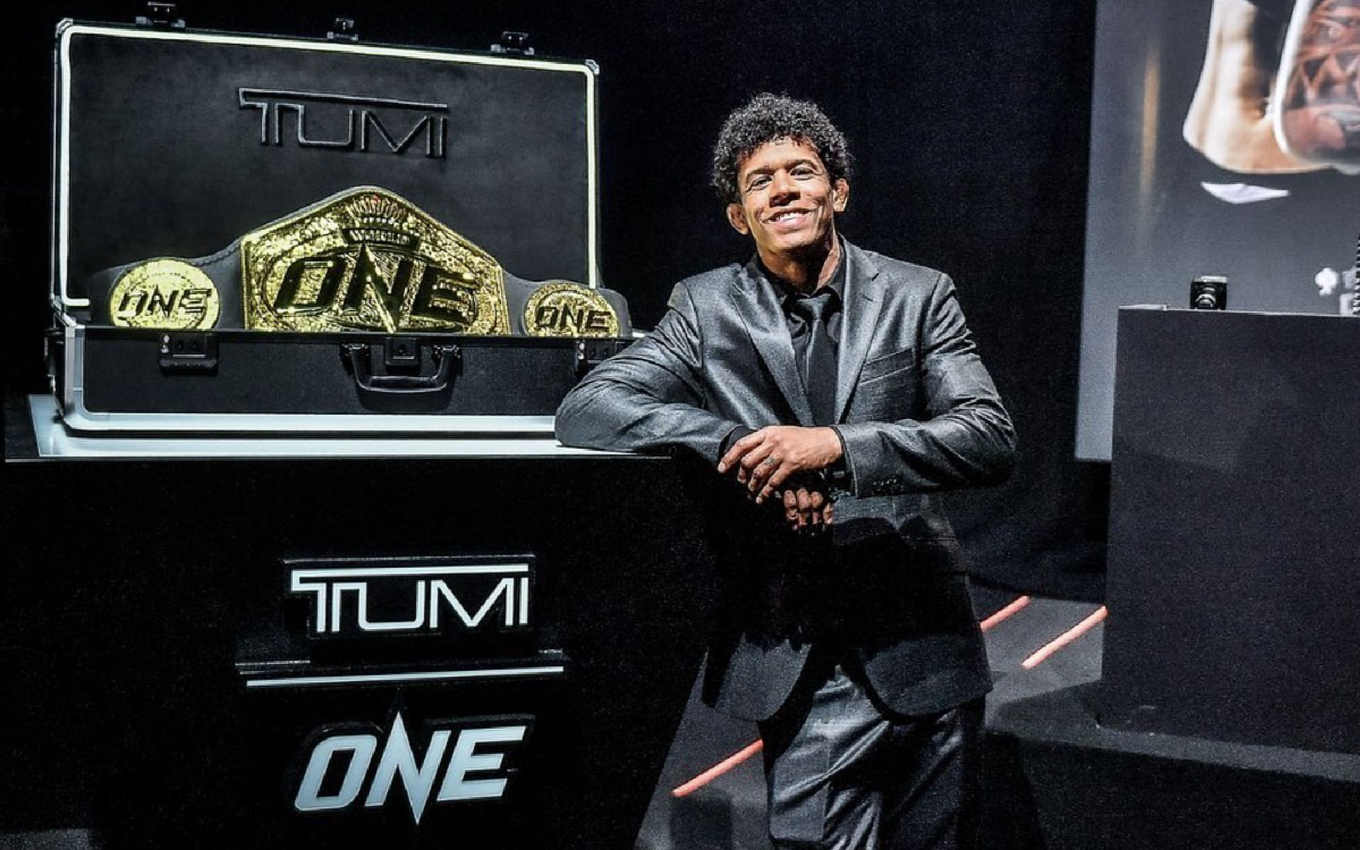 ONE flyweight world champion Adriano Moraes poses with the new ONE world title during the ONE X press conference. [Photo Adriano Moraes Instagram]