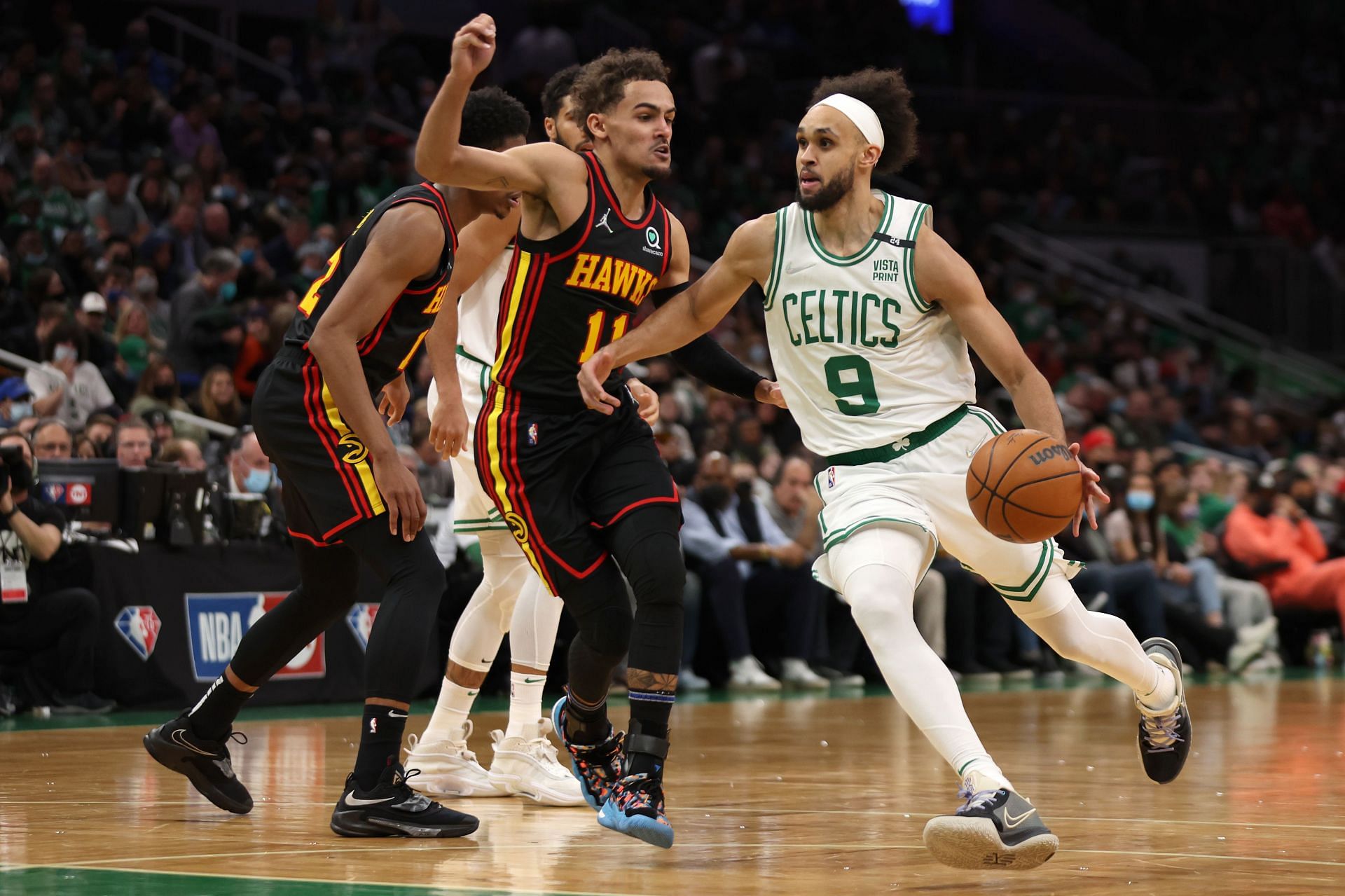 Derrick White attempts to drive past Trae Young.