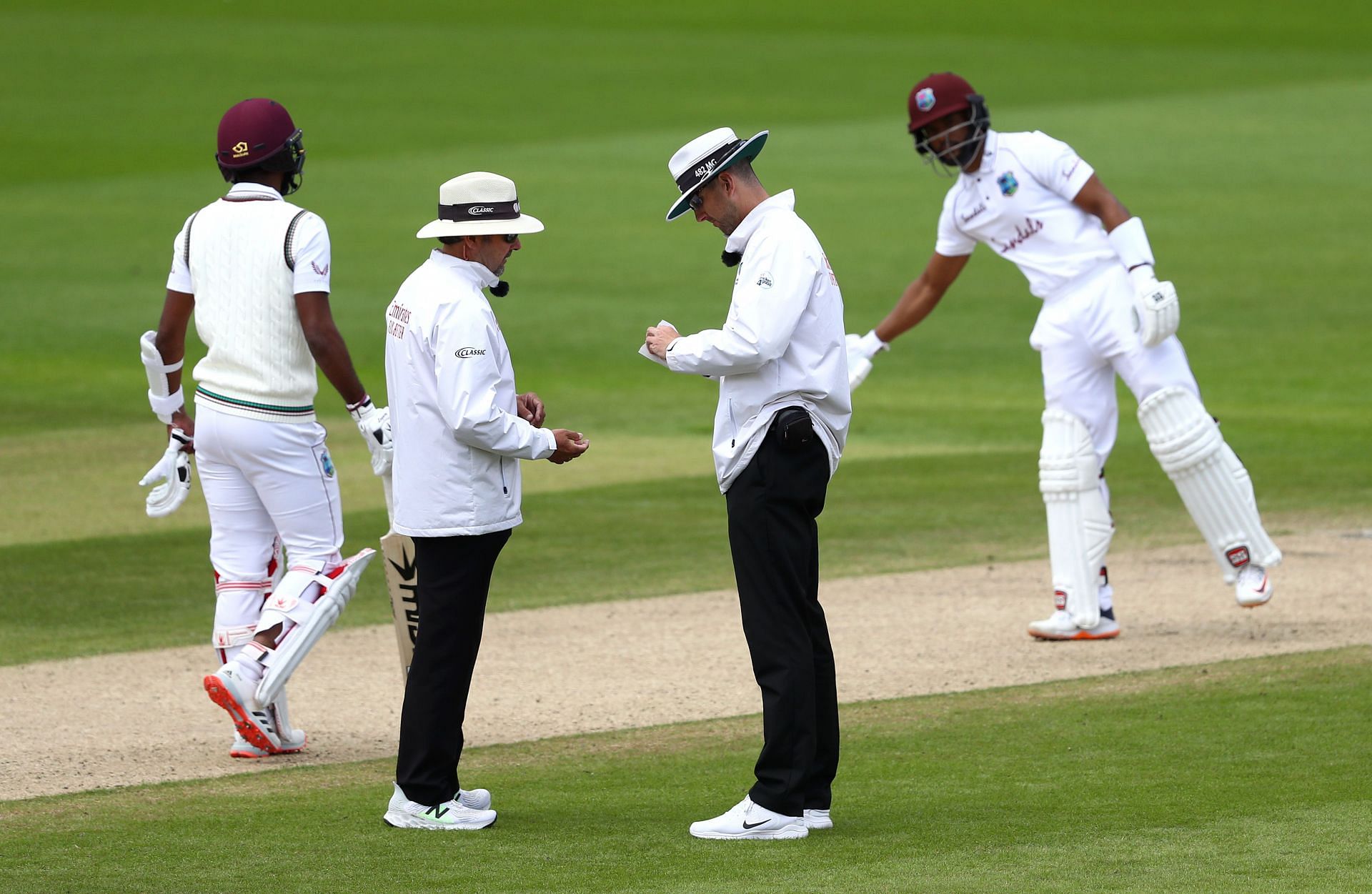 Umpires sanitise the ball after saliva is accidentally added to it during a Test at Old Trafford in July 19, 2020. Pic: Getty Images