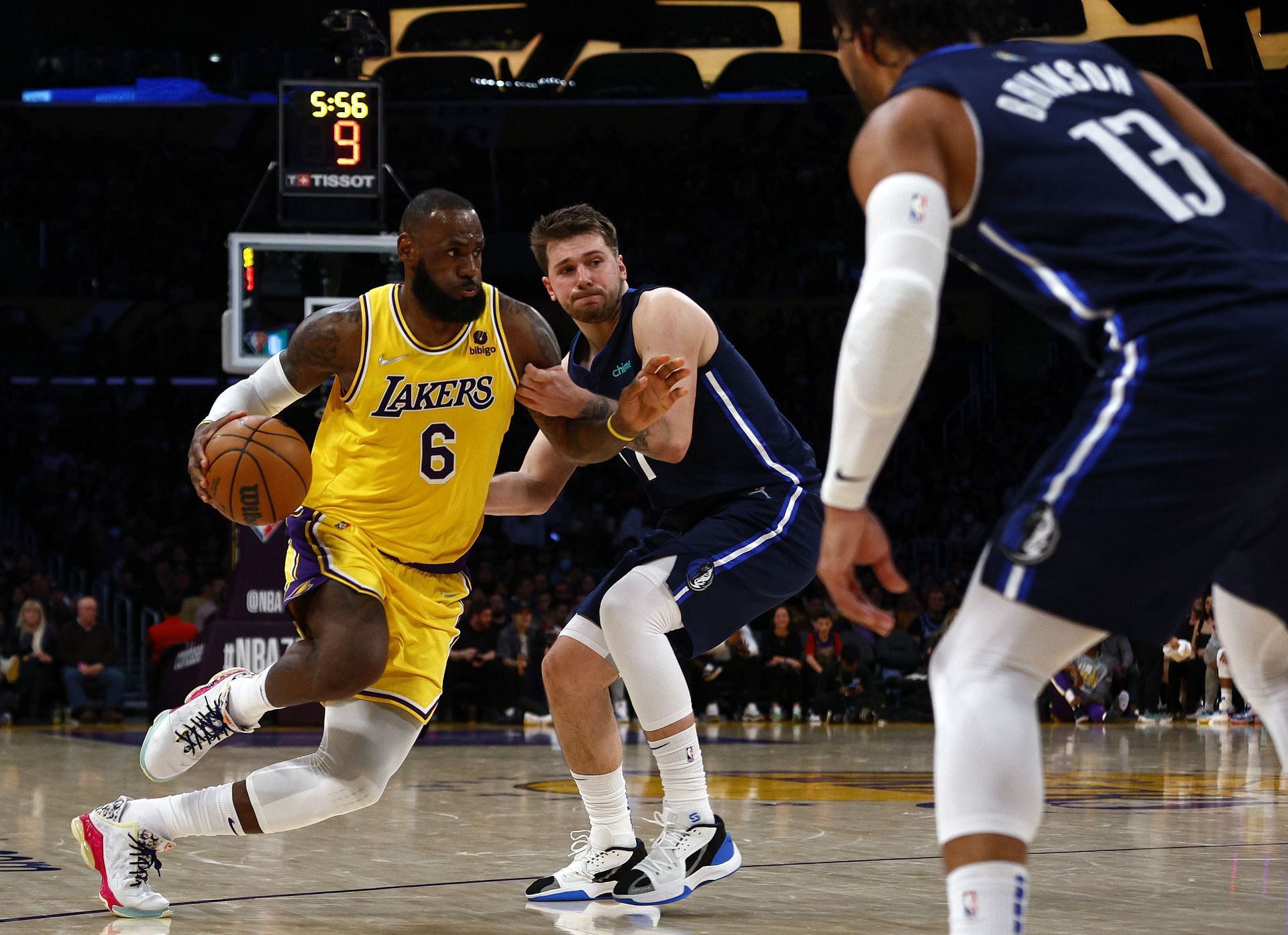 LeBron James #6 of the Los Angeles Lakers dribbles the ball against Luka Doncic #77 of the Dallas Mavericks