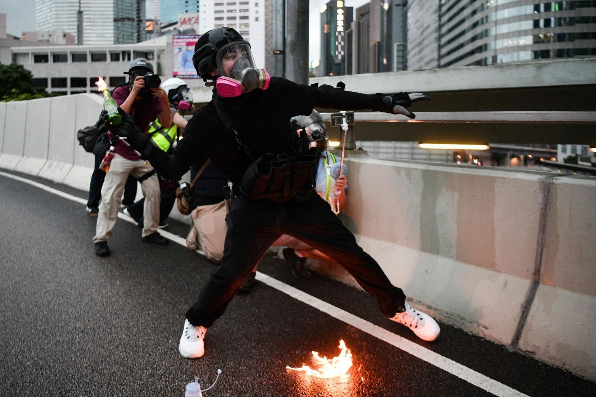 A protestor using a Molotov cocktail in Hong Kong (Image via AFP/Anthony Wallace/Getty Images)