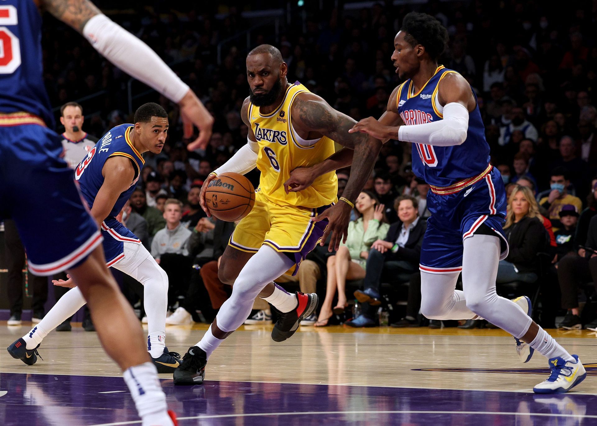 LeBron James of the LA Lakers drives to the basket between Jonathan Kuminga (00) and Jordan Poole (3) of the Golden State Warriors