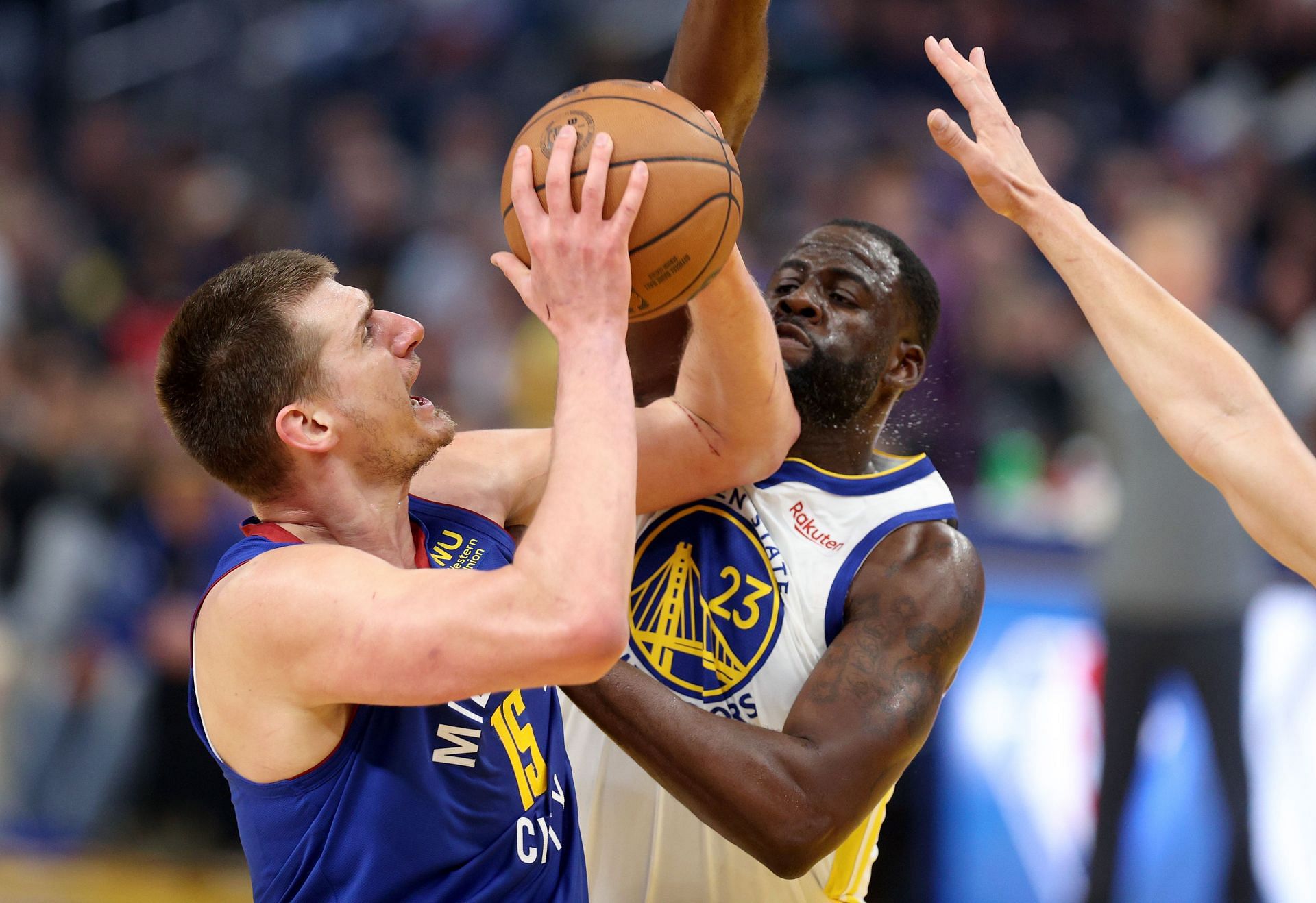 Nikola Jokic No. 15 of the Denver Nuggets shoots over Draymond Green No. 23 of the Golden State Warriors.