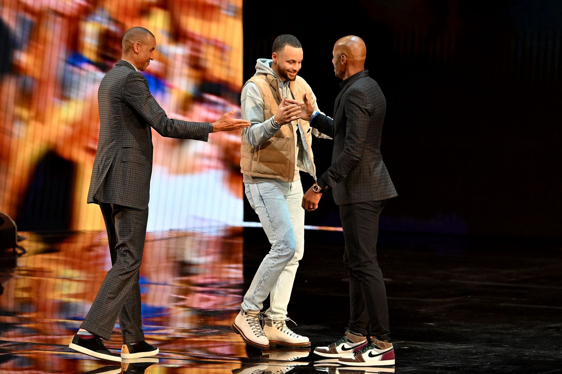 Stephen Curry #30 of the Golden State Warriors interacts with Reggie Miller and Ray Allen