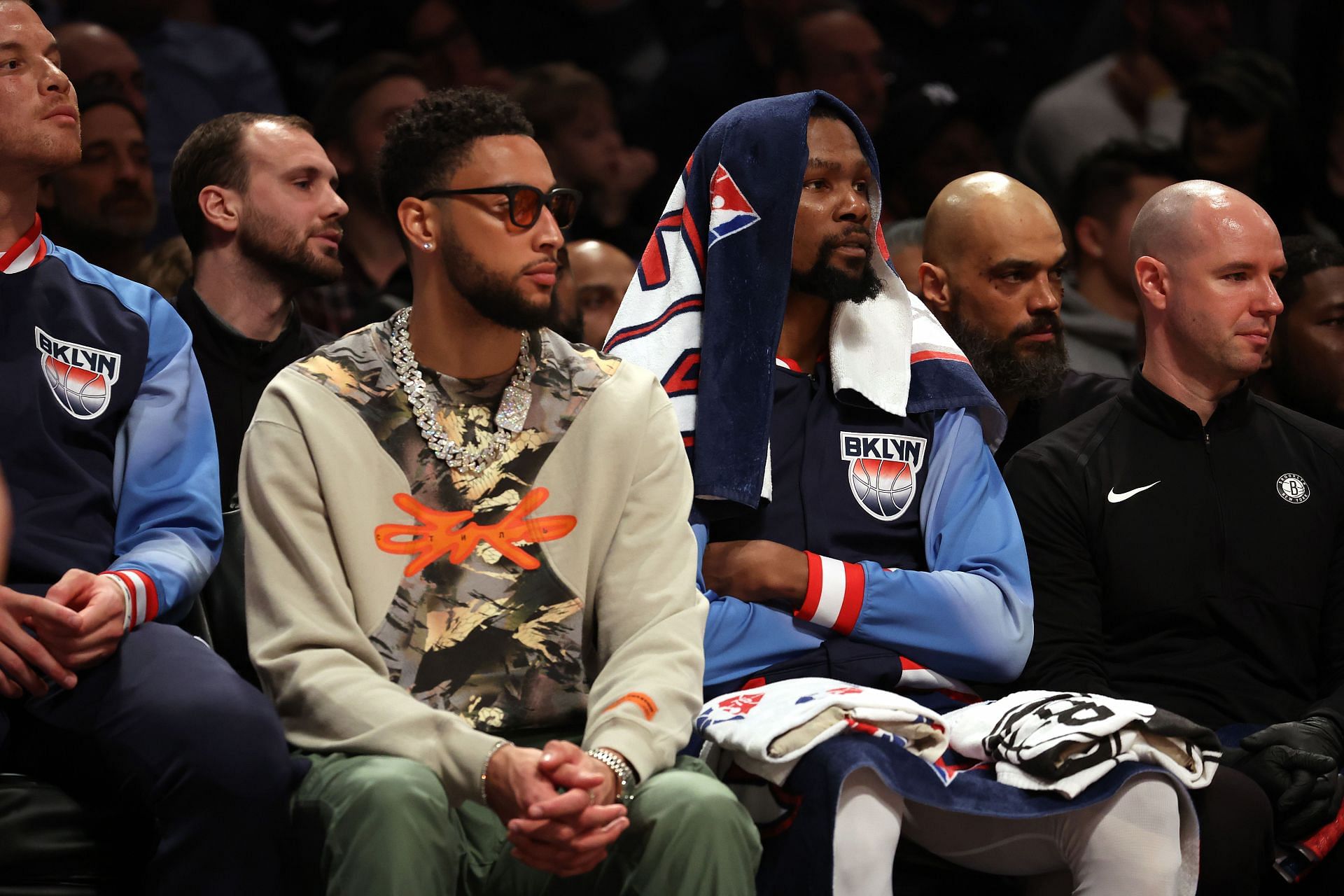 Ben Simmons watches the game alongside teammate Kevin Durant