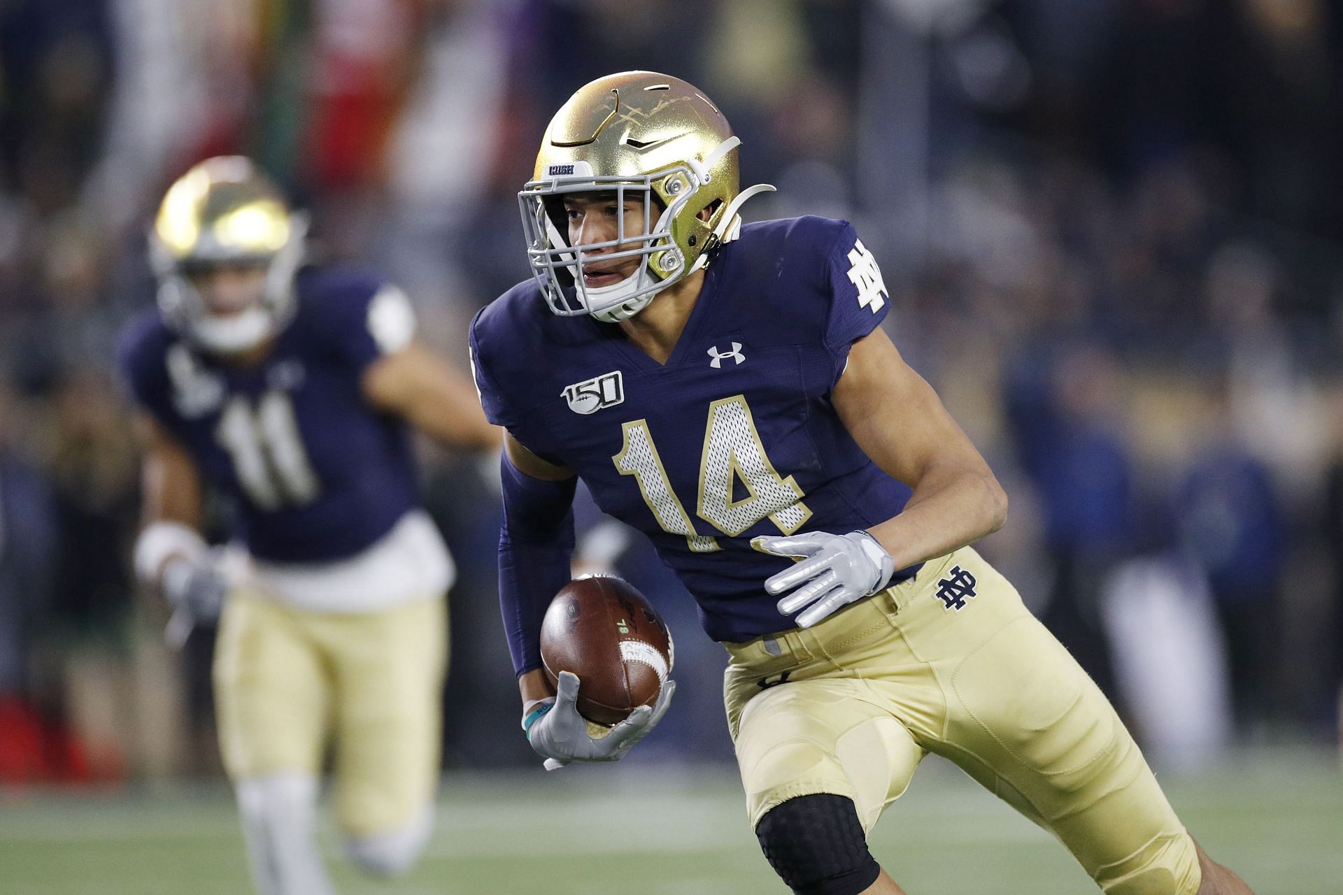 : Kyle Hamilton #14 of the Notre Dame Fighting Irish runs with the ball after intercepting a pass against the Boston College Eagles in the second half at Notre Dame Stadium on November 23, 2019 in South Bend, Indiana. Notre Dame defeated Boston College 40-7. Cincinnati Bearcats cornerback Ahmad Gardner (1) looks on during a game between the Notre Dame Fighting Irish and the Cincinnati Bearcats on October 2, 2021, in South Bend, IN.