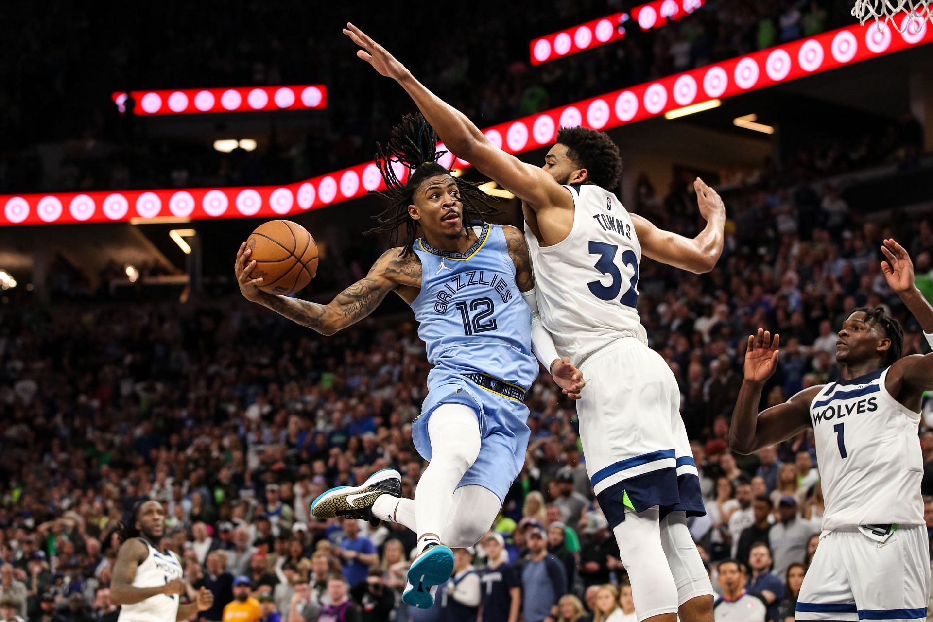 Ja Morant of the Memphis Grizzlies goes up for a shot while Karl-Anthony Towns of the Minnesota Timberwolves defends.