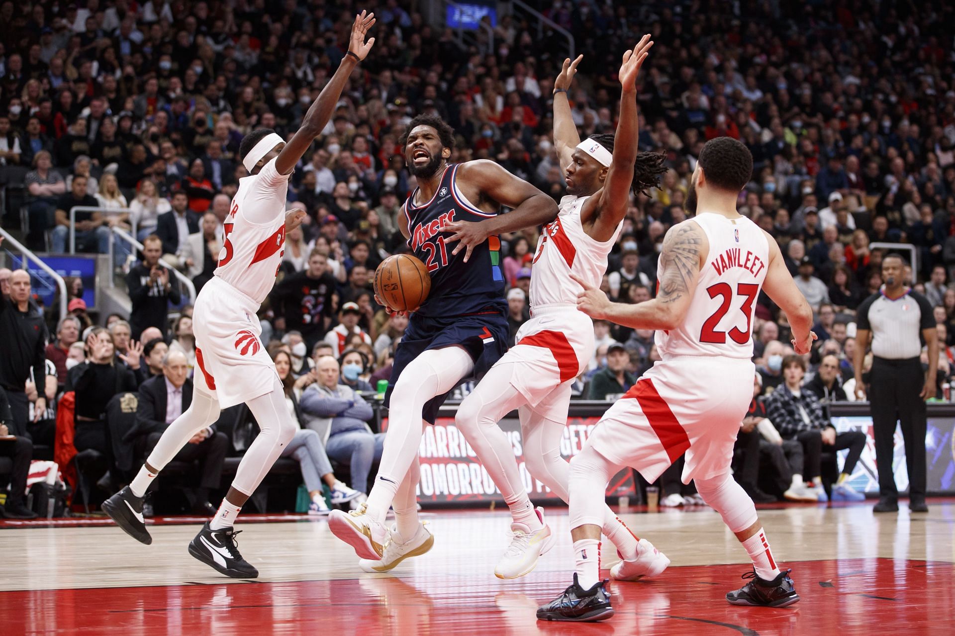 Joel Embiid #21 of the Philadelphia 76ers drives to the net against Chris Boucher #25 and Precious Achiuwa #5 of the Toronto Raptors