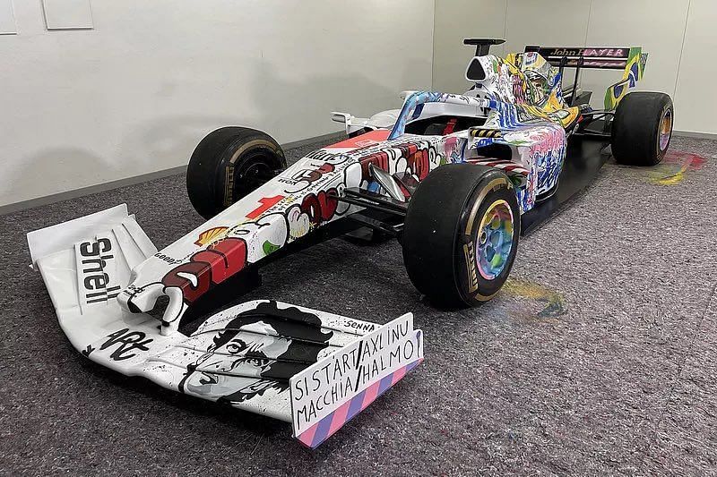 The McLaren has graffiti dedicated to Senna on one side and a medley of his various racing liveries on the other. (Image via @f1aholic on Twitter)