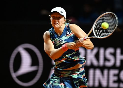 Iga Swiatek strikes a backhand against Emma Raducanu in Stuttgart.