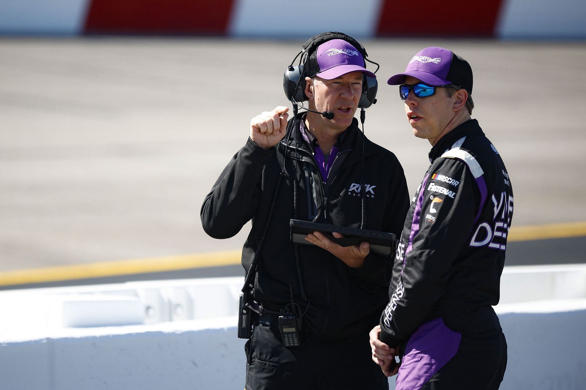 Brad Keselowski speaks with a crew member on the grid during qualifying for the NASCAR Cup Series Toyota Owners 400 at Richmond Raceway.