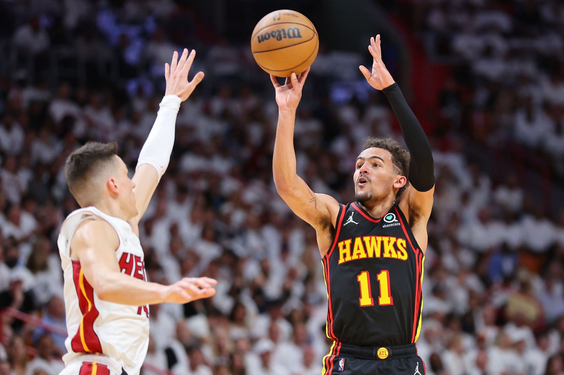 Trae Young No. 11 of the Atlanta Hawks shoots a three pointer over Tyler Herro No. 14 of the Miami Heat.