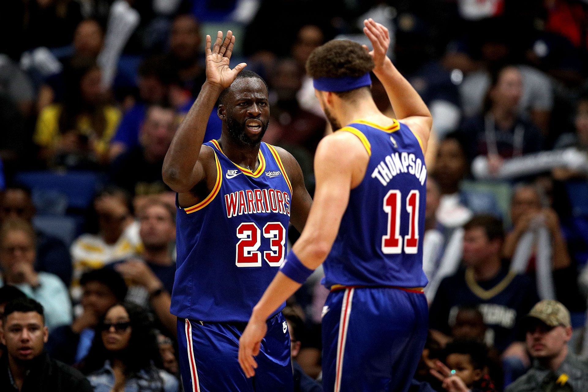 Draymond Green #23 of the Golden State Warriors and Klay Thompson #11 of the Golden State Warriors reacts after scoring a basket during the second quarter of an NBA game against the New Orleans Pelicans at Smoothie King Center on April 10, 2022 in New Orleans, Louisiana.
