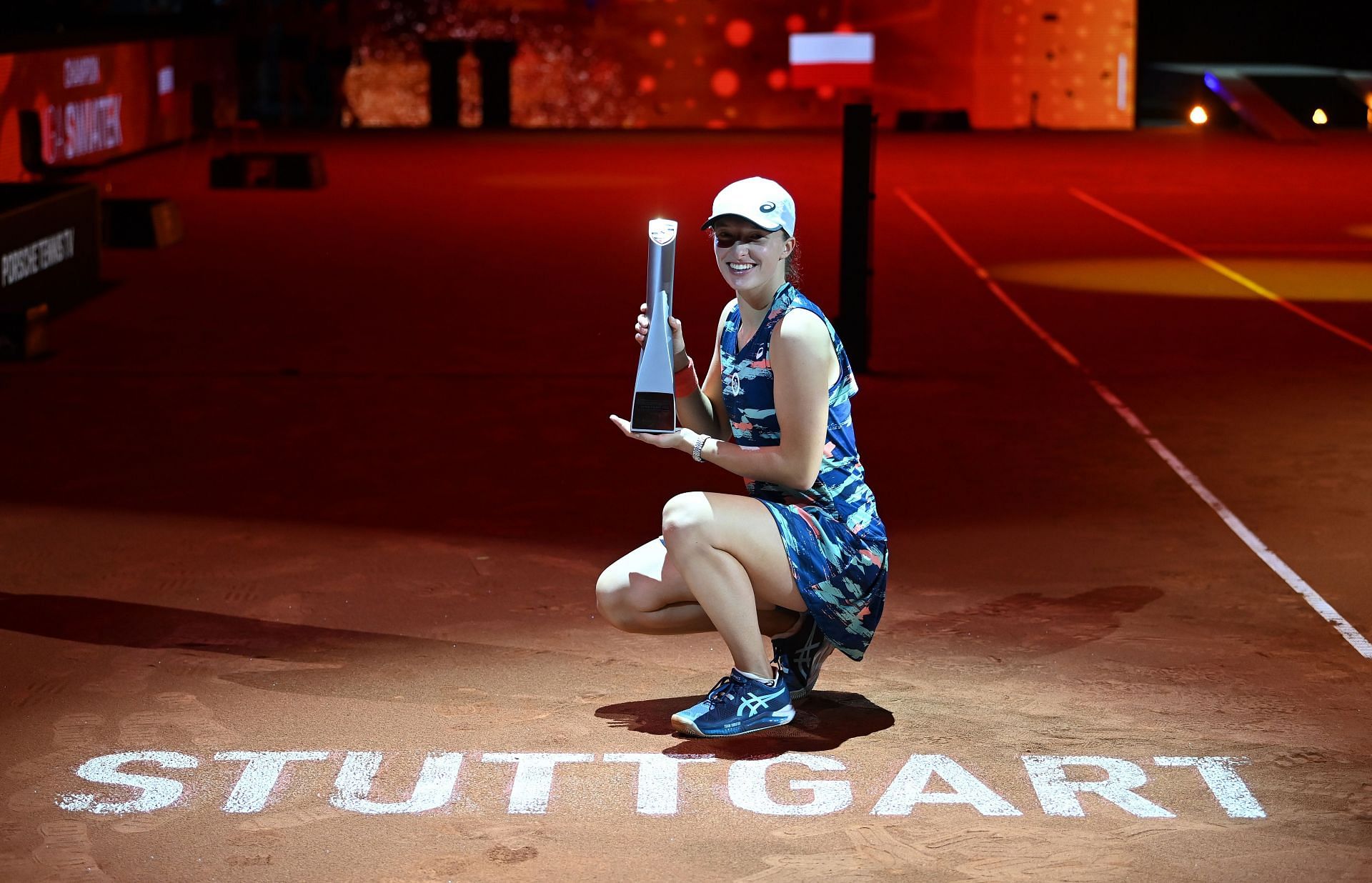 Iga Swiatek poses with her fourth trophy this season in Stuttgart