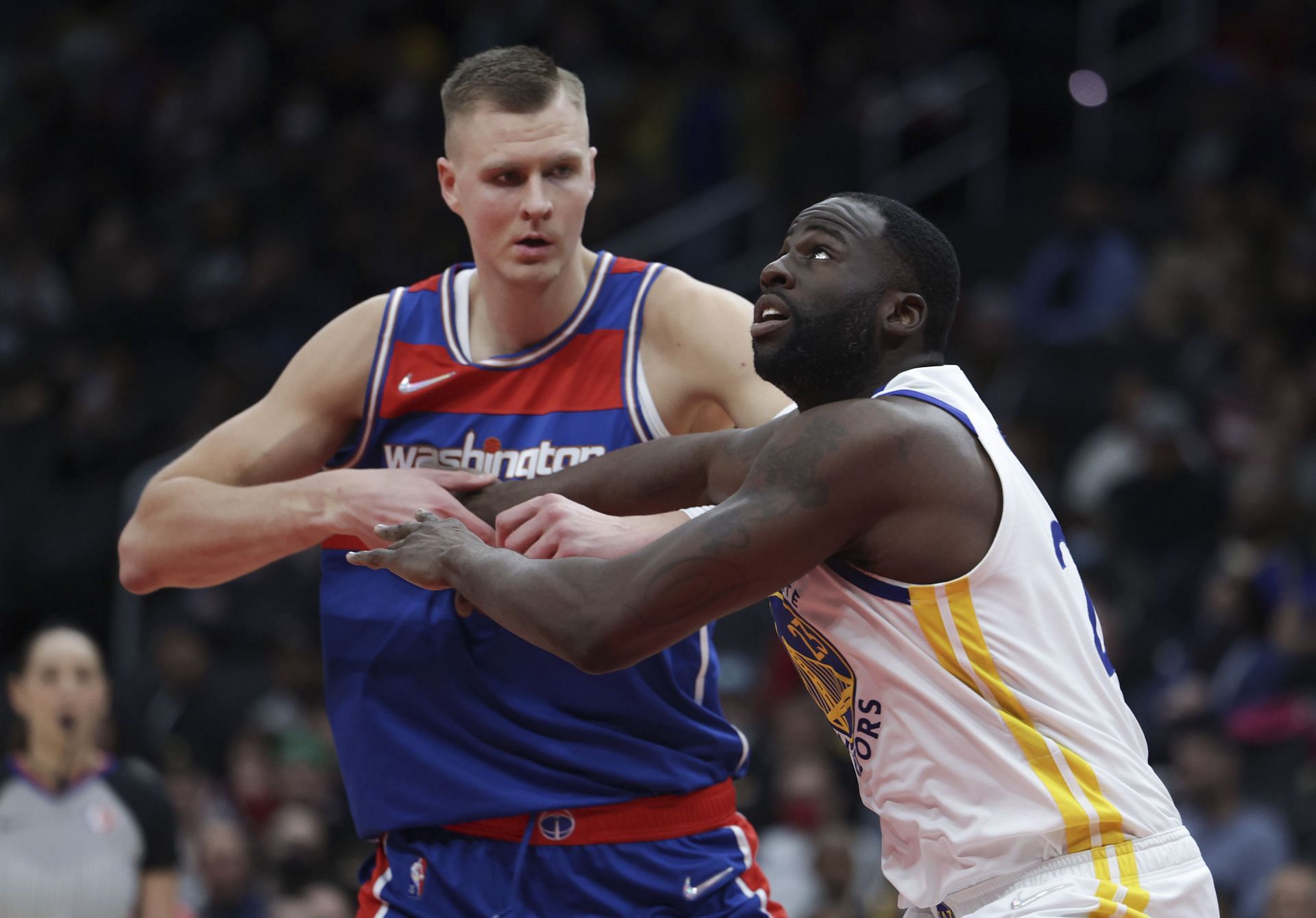 Draymond Green #23 of the Golden State Warriors and Kristaps Porzingis #6 of the Washington Wizards go for a rebound