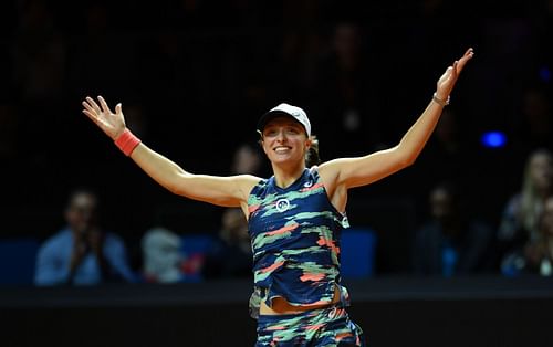 Iga Swiatek raises both arms as she beats Aryna Sabalenka in Stuttgart to go 4-0 in finals this season