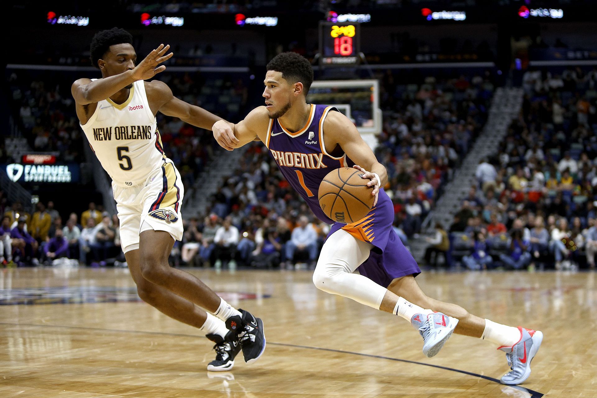 Devin Booker of the Suns is defended by Herbert Jones of the Pelicans