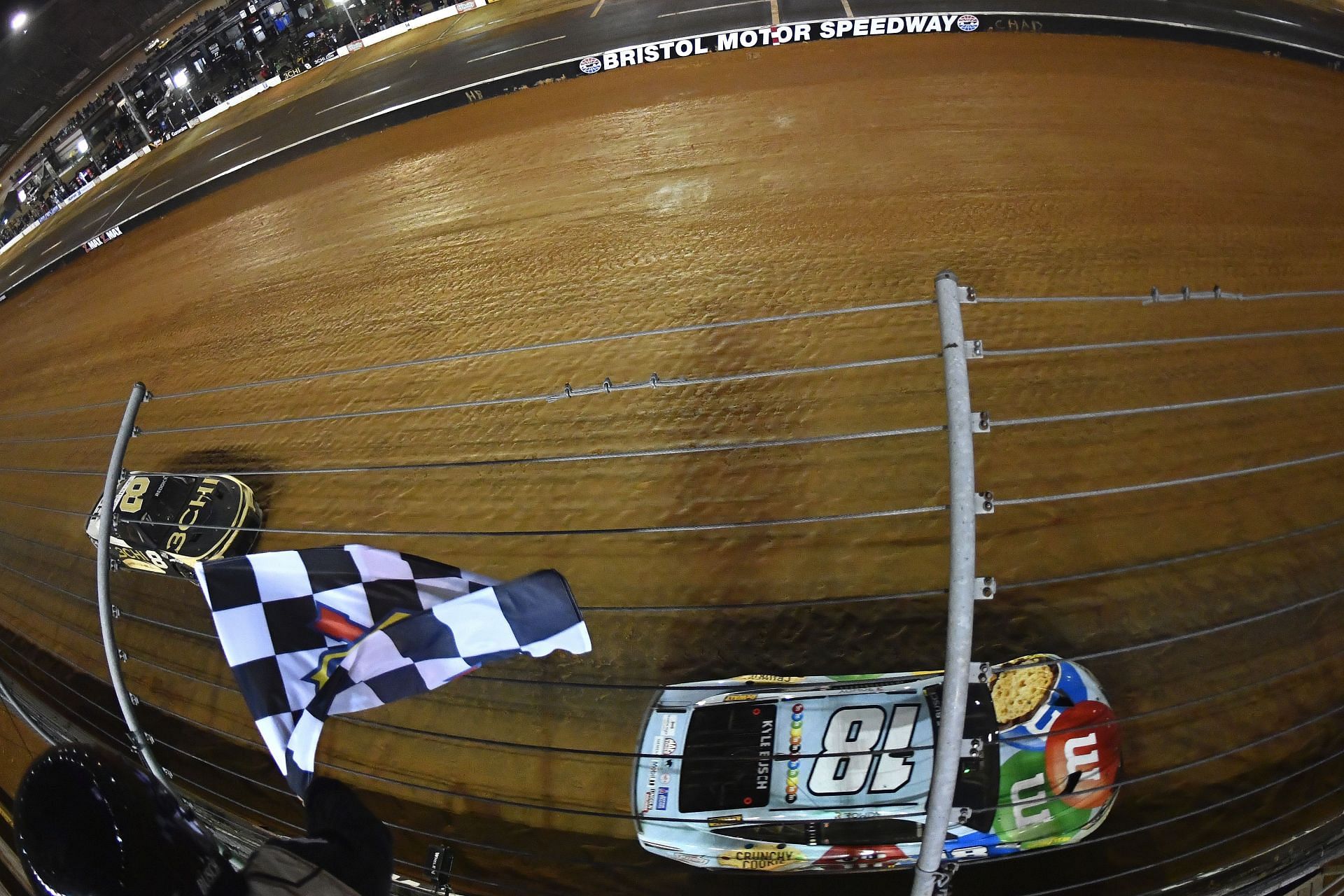 Kyle Busch takes the checkered flag to win the NASCAR Cup Series Food City Dirt Race at Bristol Motor Speedway.