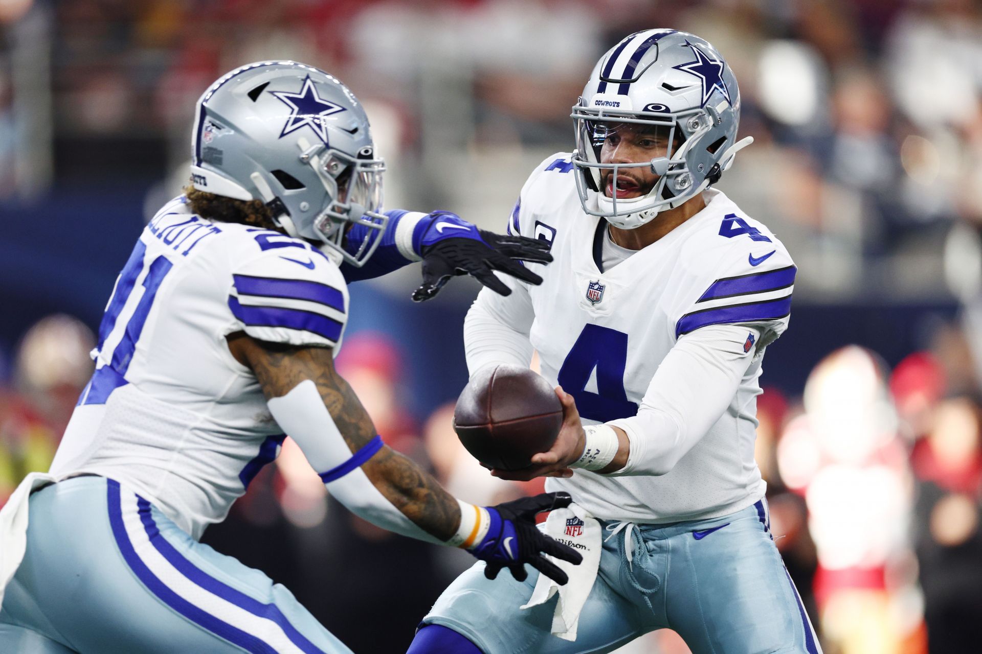 Dallas Cowboys quarterback Dak Prescott hands the ball off to Ezekiel Elliot