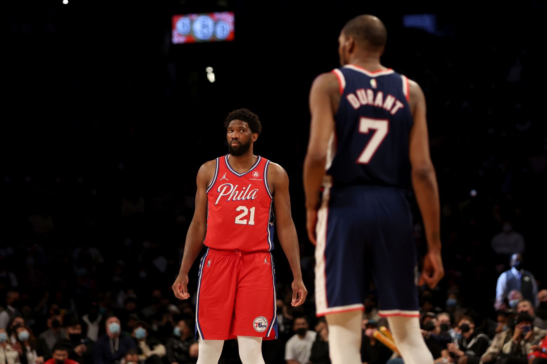 Joel Embiid #21 of the Philadelphia 76ers looks towards Kevin Durant #7 of the Brooklyn Nets