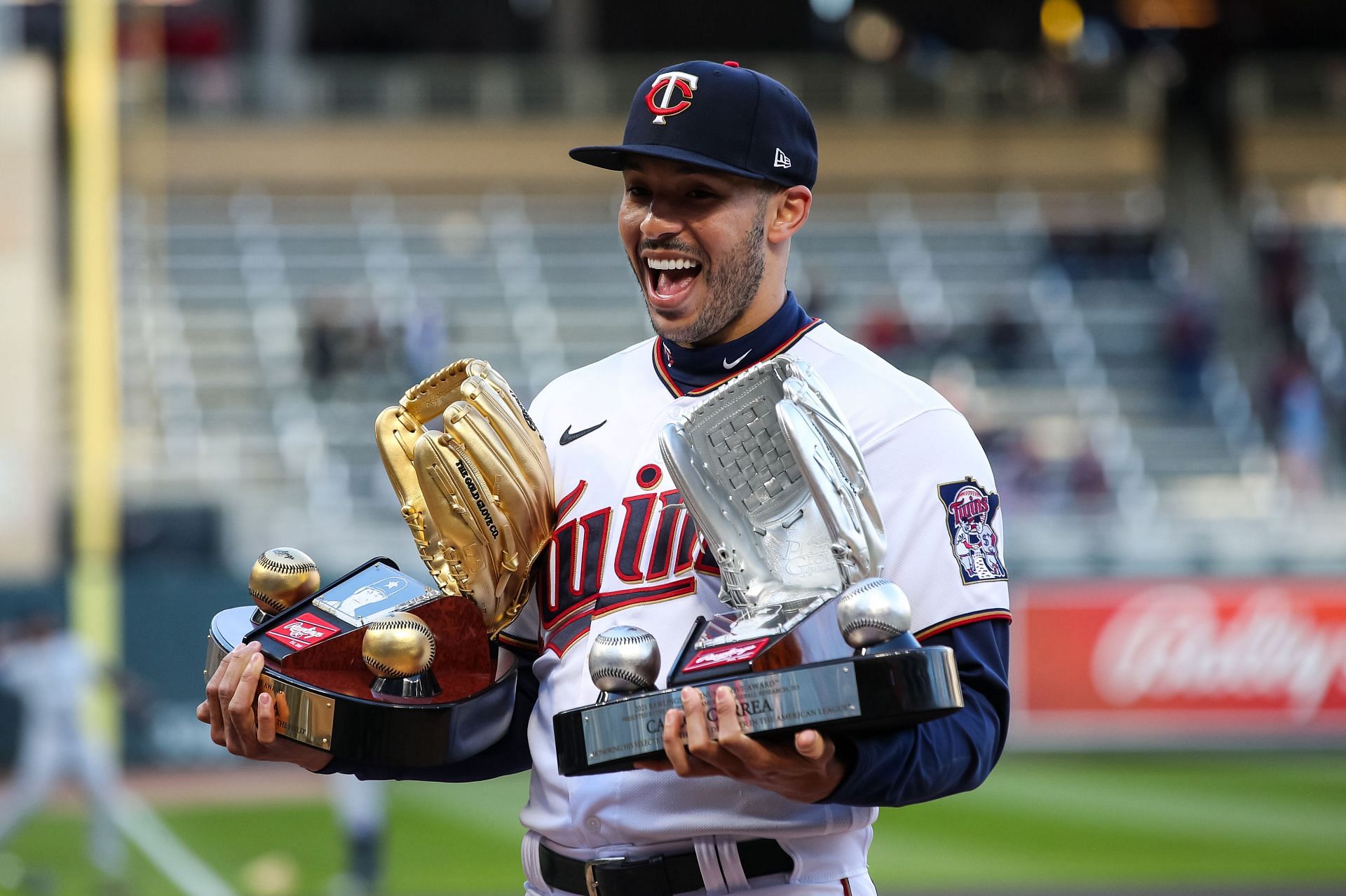 Carlos Correa posing with his Gold Glove and Platinum Glove Awards