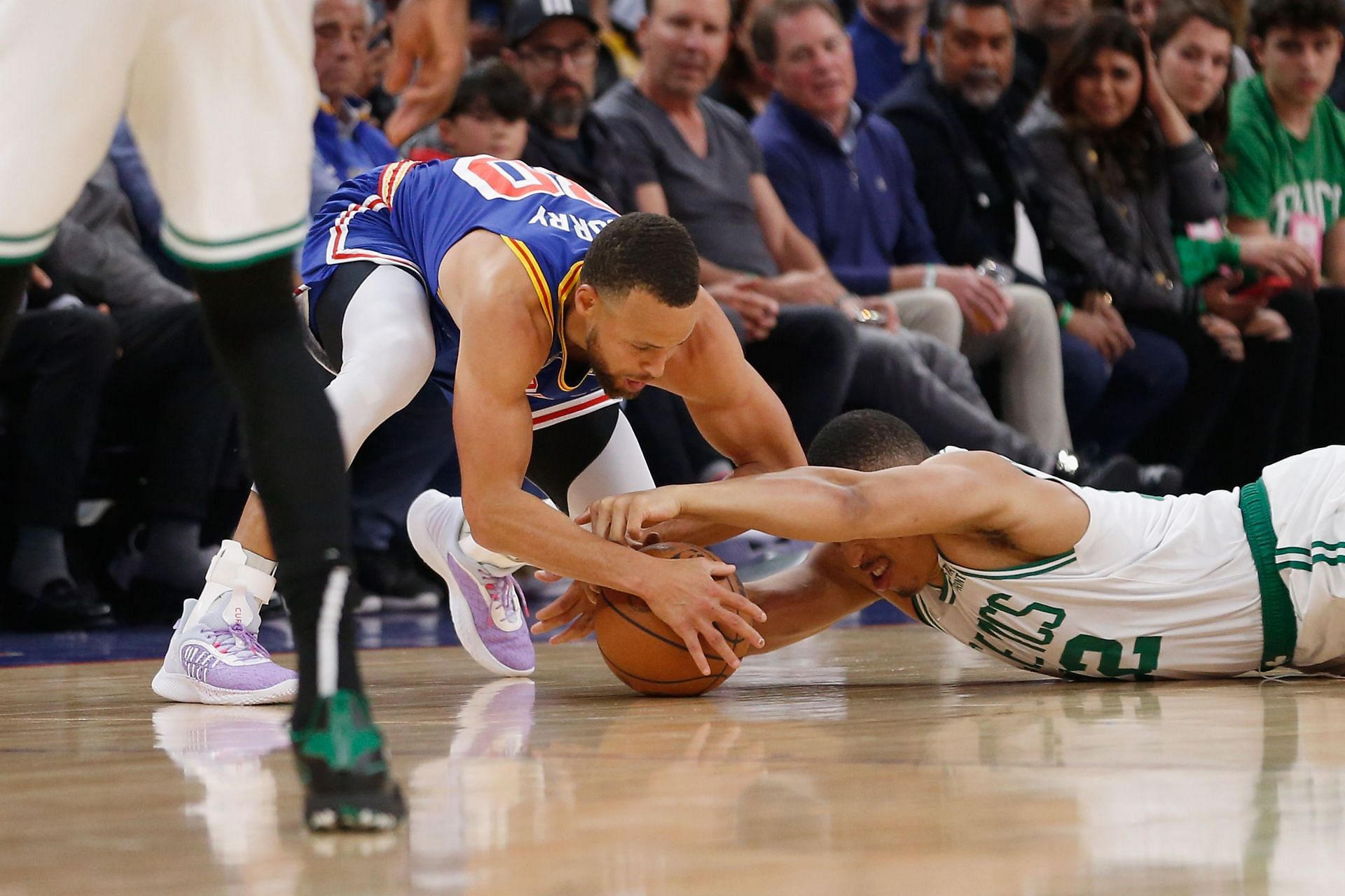 Steph Curry #30 of the Golden State Warriors competes for a loose ball against Grant Williams #12 of the Boston Celtics