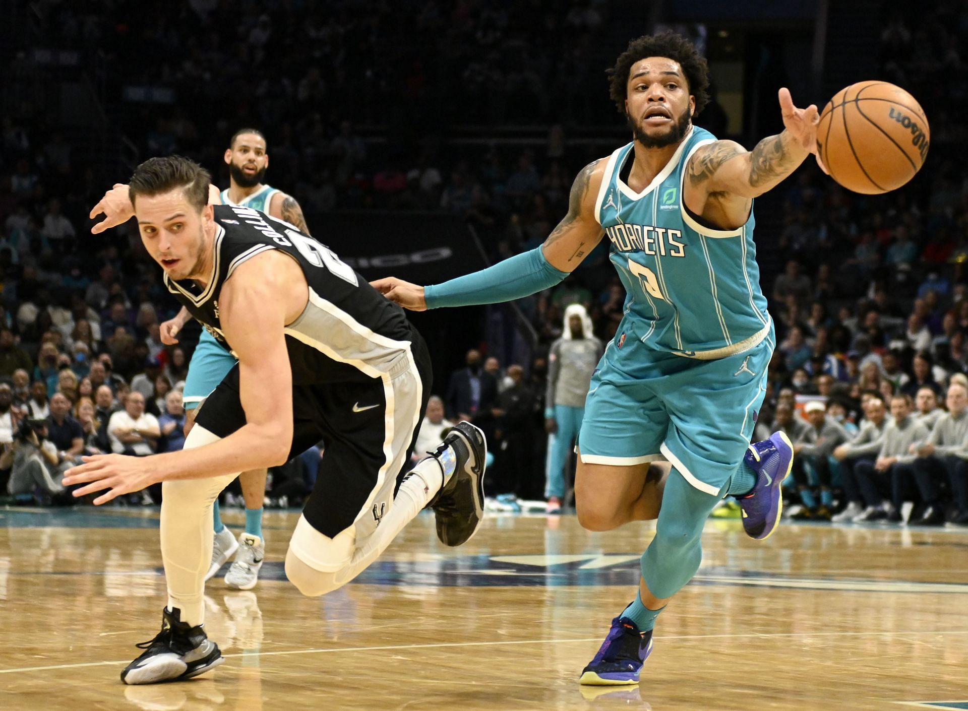 Miles Bridges of the Charlotte Hornets reaches for the ball after it was knocked out of his grip by Zach Collins of the San Antonio Spurs on March 5 in Charlotte, North Carolina.
