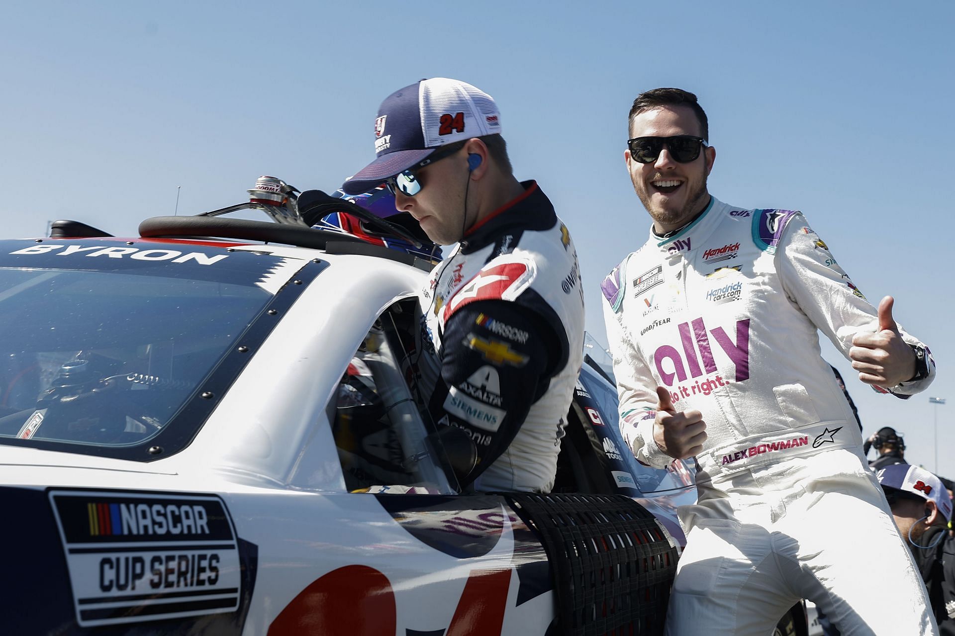 Alex Bowman poses for a photo as William Byron enters his car during qualifying for the 2022 NASCAR Cup Series Toyota Owners 400 at Richmond Raceway in Virginia. (Photo by Jared C. Tilton/Getty Images)