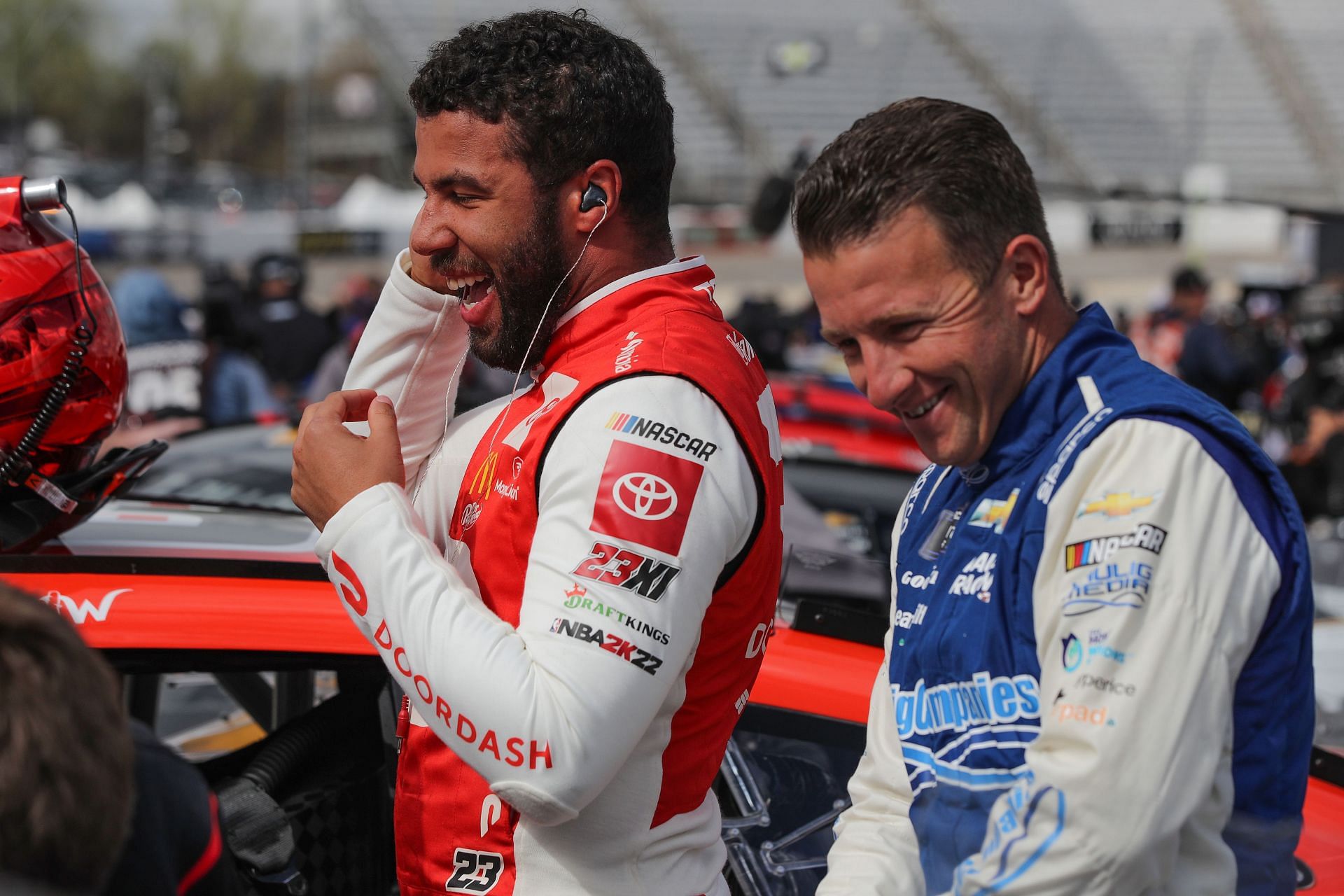 AJ Allmendinger (right) and Bubba Wallace (left) share a laugh on the grid during practice for the NASCAR Cup Series Blue-Emu Maximum Pain Relief 400 at Martinsville Speedway.