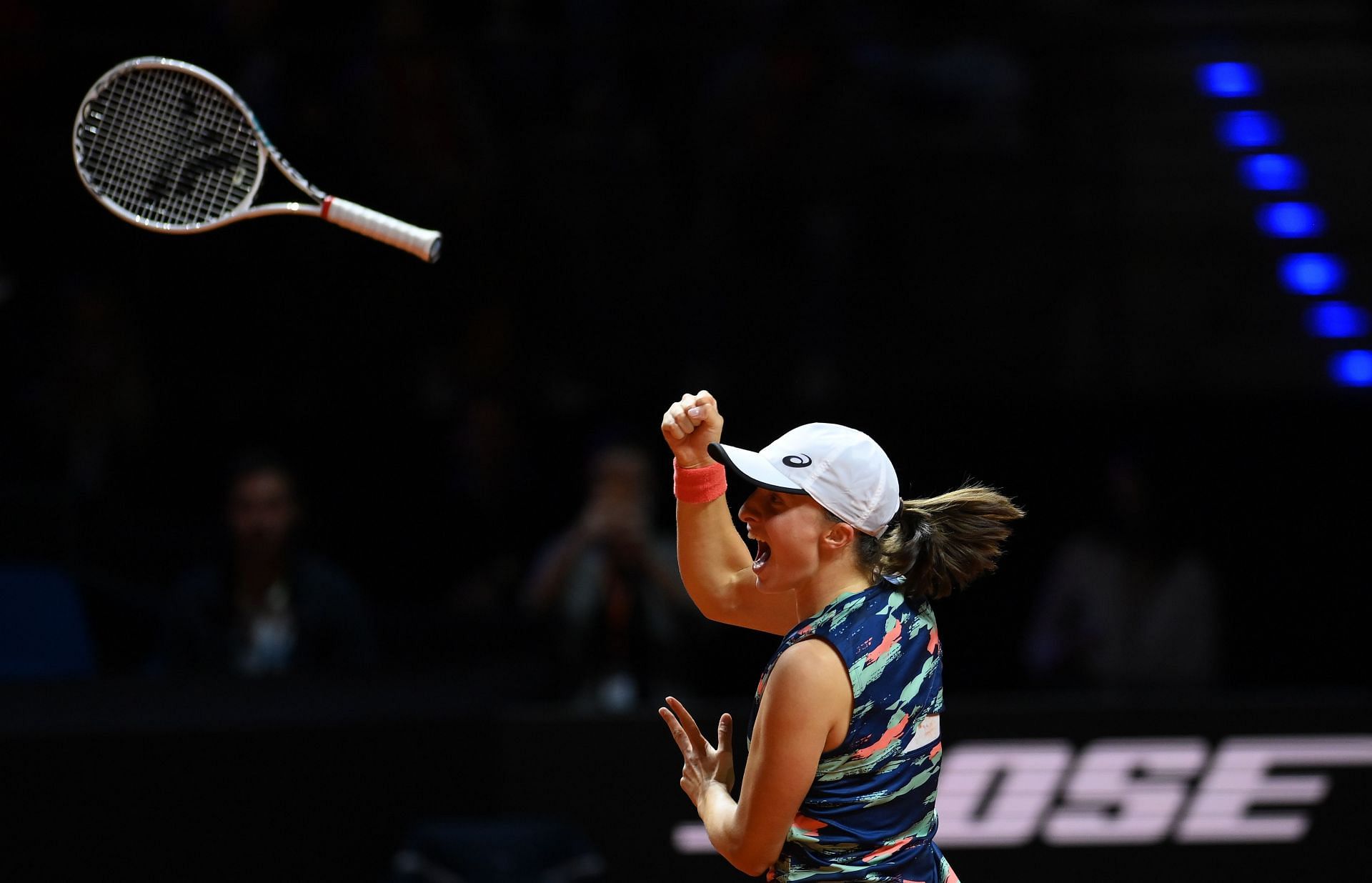 Iga Swiatek throws her racket up in the air in delight after beating Aryna Sabalenka in the Stuttgart final