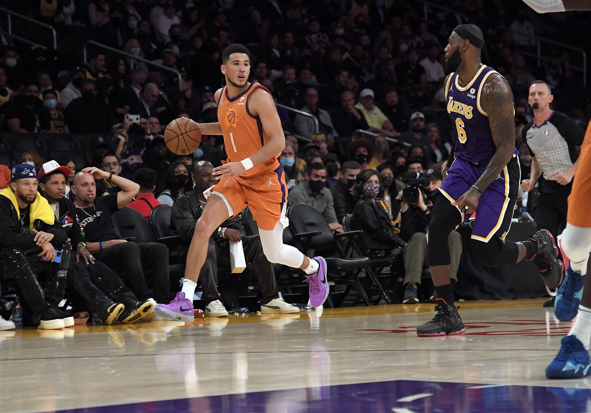 Devin Booker of the Phoenix Suns looks to pass against LeBron James of the LA Lakers.