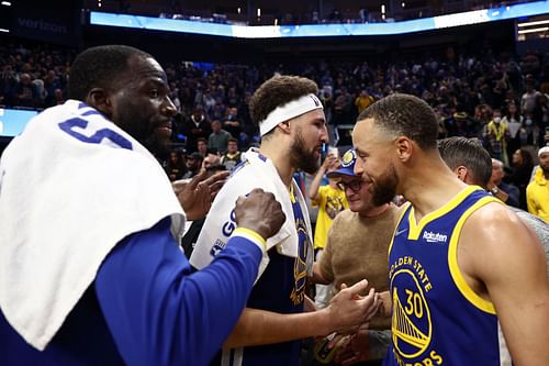 Stephen Curry No. 30, Klay Thompson No. 11 and Draymond Green No. 23 of the Golden State Warriors congratulate one another after a victory over the Washington Wizards.