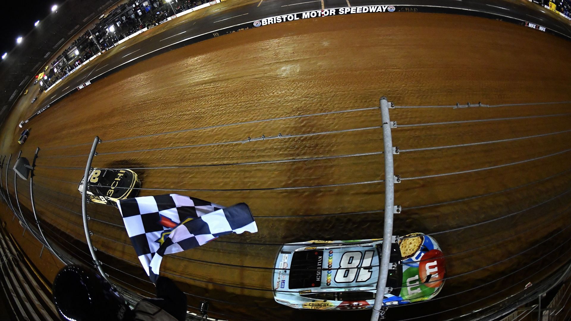 Kyle Busch takes the checkered flag ahead of Tyler Reddick to win the NASCAR Cup Series Food City Dirt Race at Bristol Motor Speedway. (Photo by Logan Riely/Getty Images)