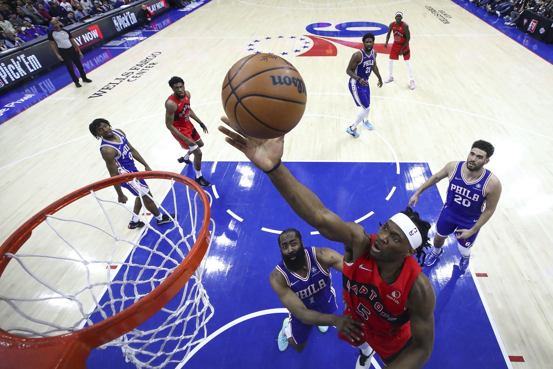 Precious Achiuwa No. 5 of the Toronto Raptors lays it up over James Harden No. 1 of the Philadelphia 76ers.