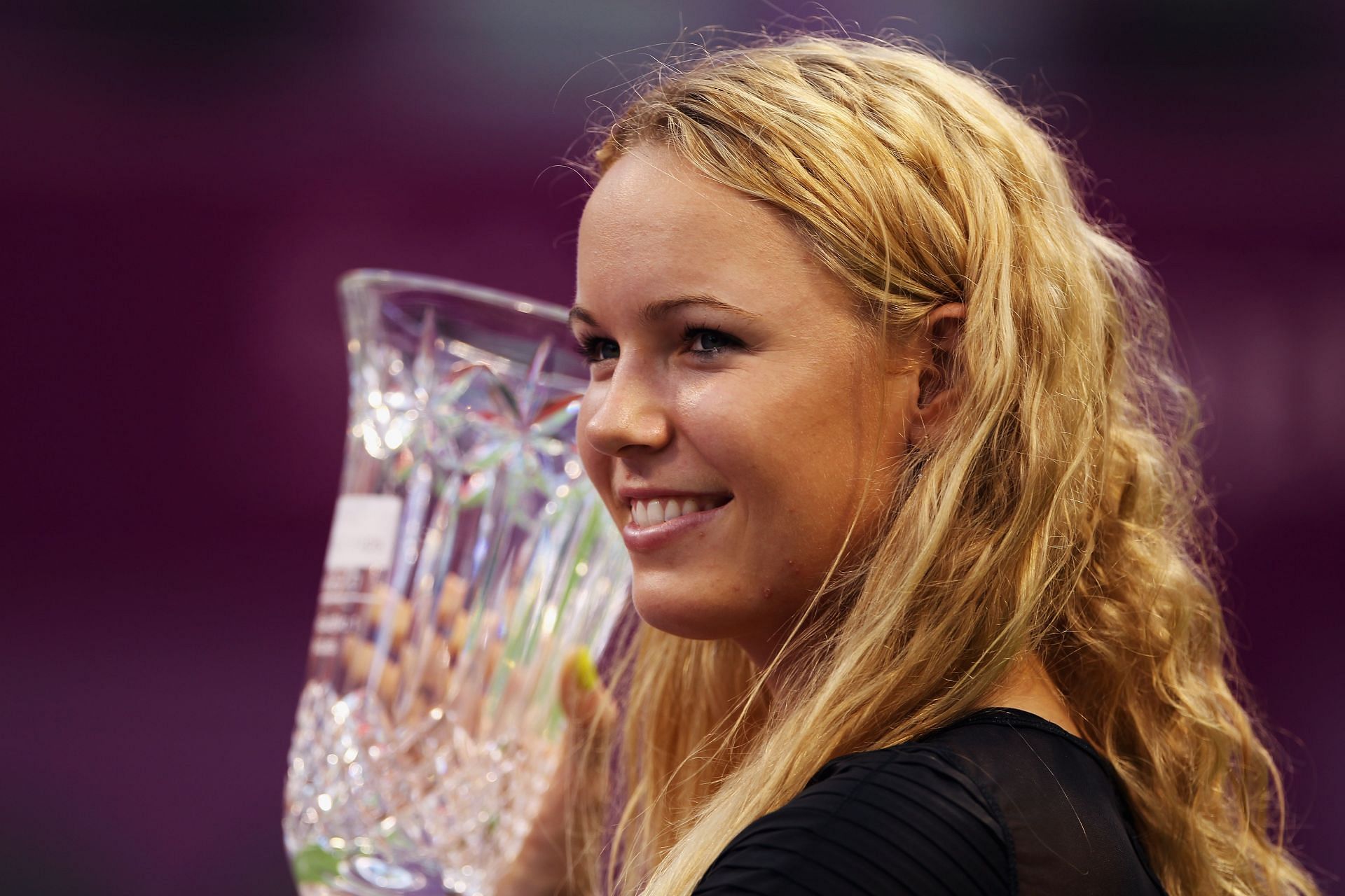 Caroline Wozniacki smiles as she holds the year-end No. 1 trophy at the WTA Championships on October 29, 2010 in Doha.