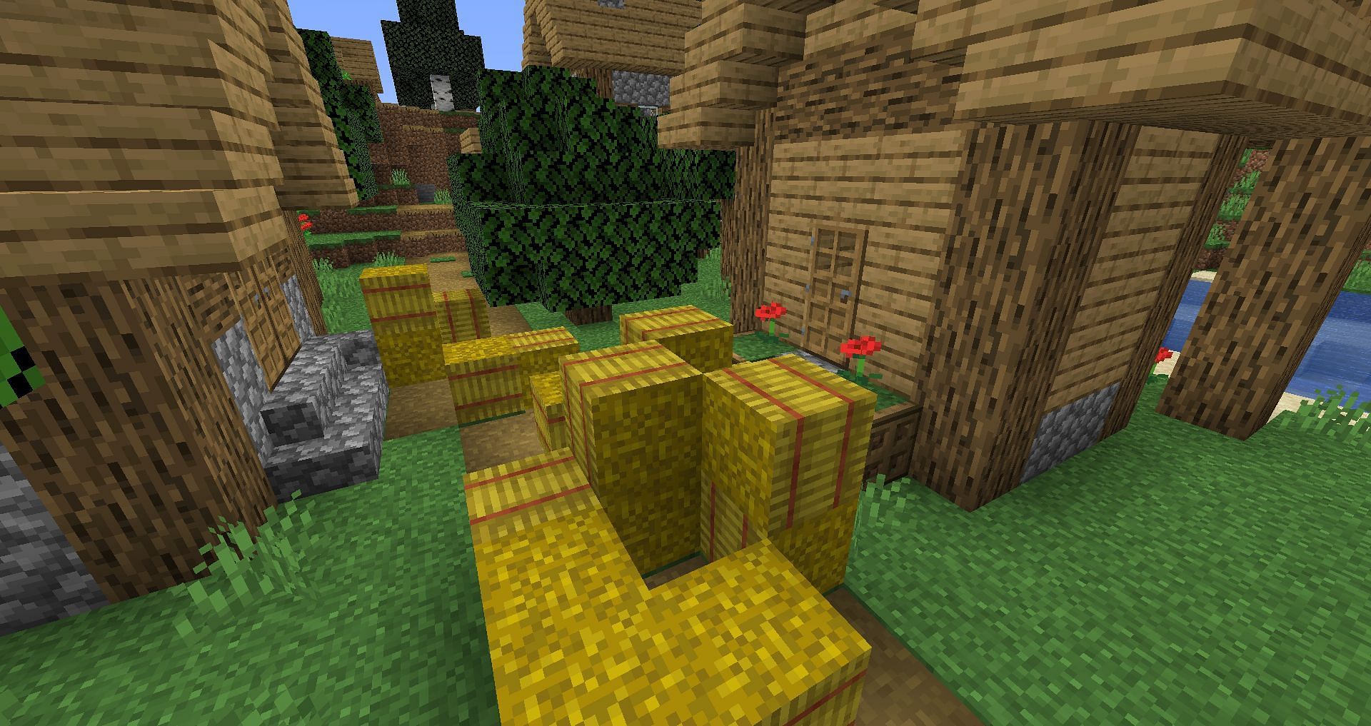 A large stack of hay bales in a village (Image via Minecraft)