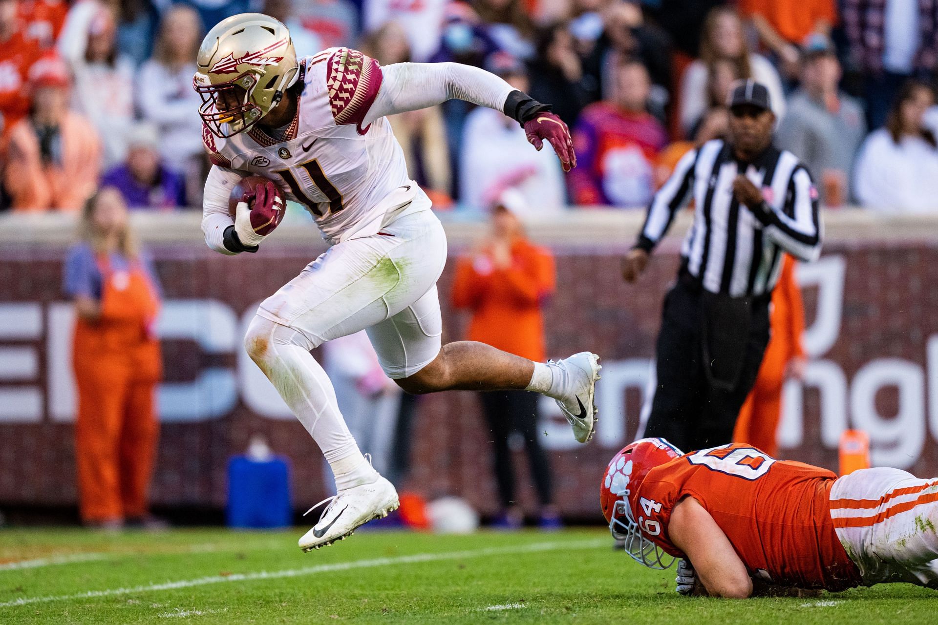 Defensive end Jermaine Johnson II #11 of the Florida State Seminoles scores a defensive touchdown while eluding offensive lineman Walker Parks #64 of the Clemson Tigers during the fourth quarter during their game at Clemson Memorial Stadium on October 30, 2021 in Clemson, South Carolina.