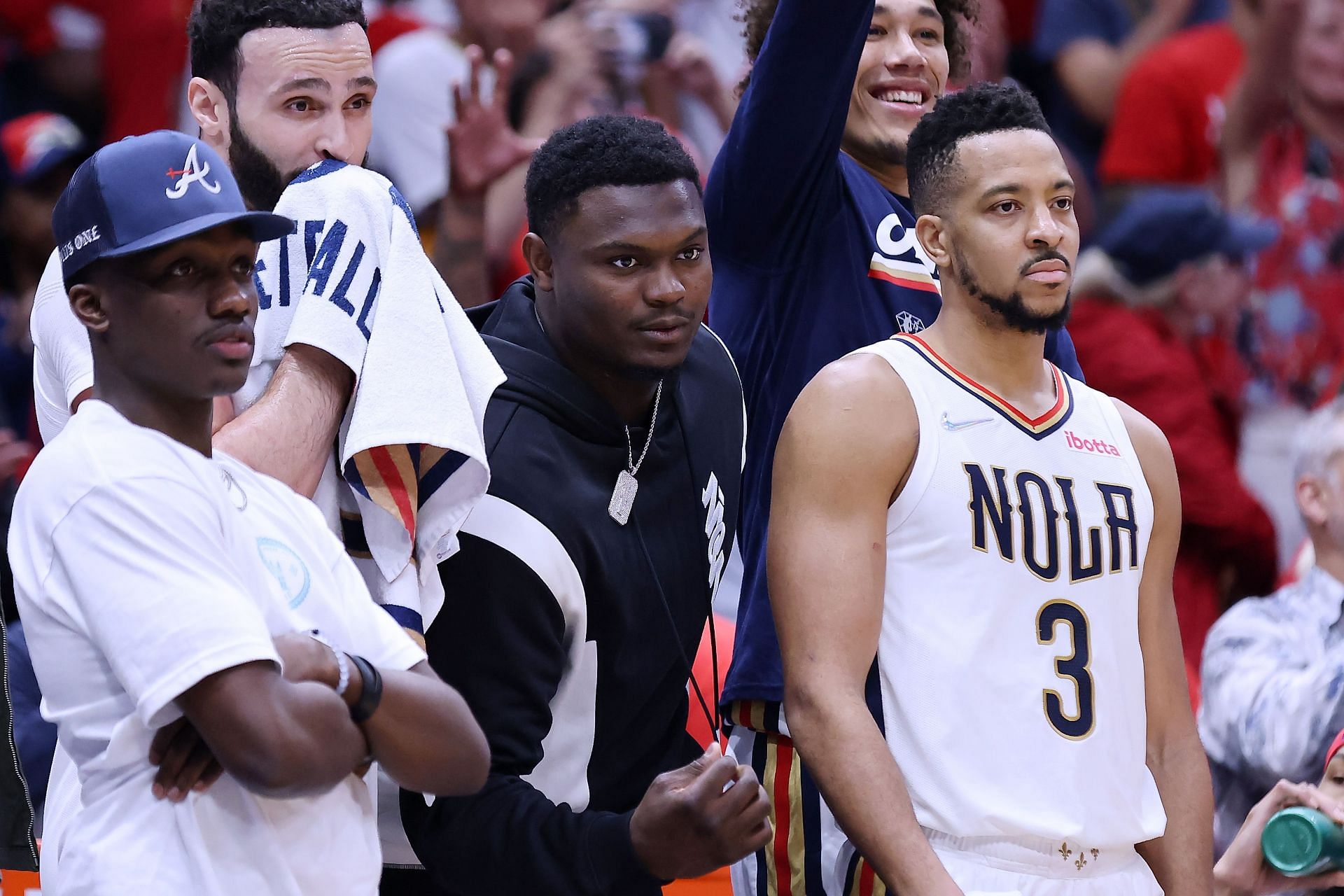 Zion Williamson (middle) of the New Orleans Pelicans on the bench with CJ McCollum (right)