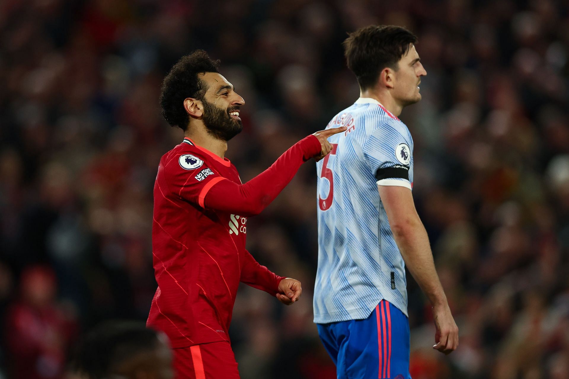 Mohamed Salah celebrates (L) as a dejected Harry Maguire (R) looks on