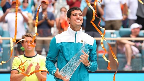 Carlos Alcaraz with the Miami Open trophy as Casper Ruud applauds