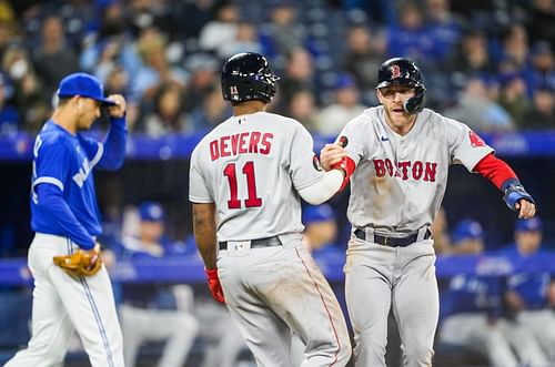 Red Sox teammates Devers and Story celebrate after a run is scored in last week's 7-1 victory over the Toronto Blue Jays at Rogers Centre in Toronto.