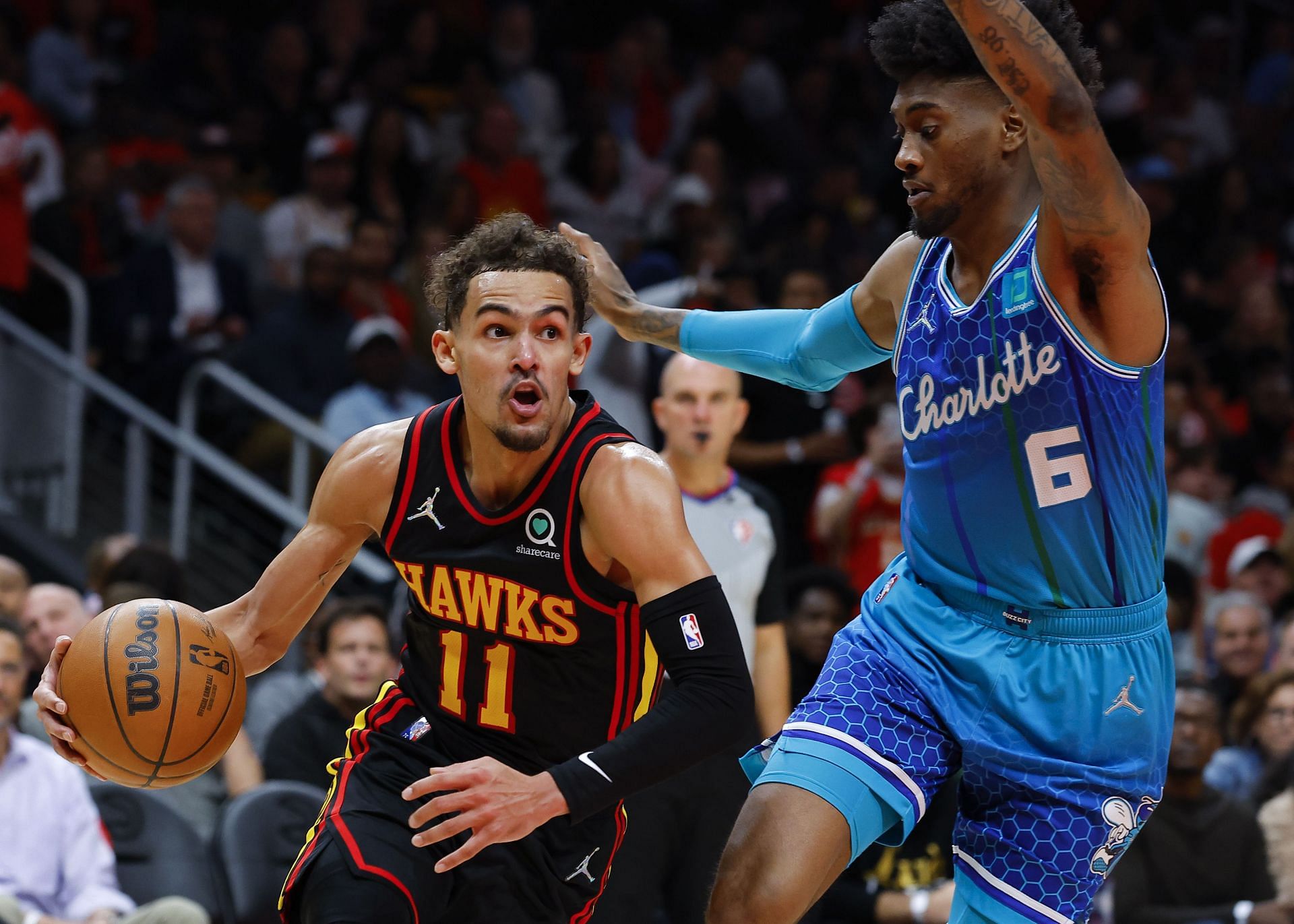 Trae Young of the Atlanta Hawks dribbles the ball against Jalen McDaniels No. 6 of the Charlotte Hornets.