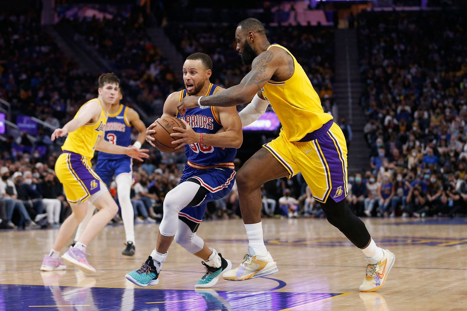 Stephen Curry of the Golden State Warriors drives to the basket against LeBron James of the LA Lakers.